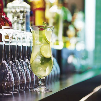 Cocktail serveret i Arcoroc Hurricane glas på bar med lime og mynte – professionelt cocktailglas i brug